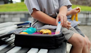 School child with lunch box and epi-pen for anaphylaxis.